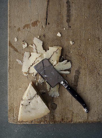 Ein Abgenutztes Schneidebrett, auf dem Käse geschnitten wurde.